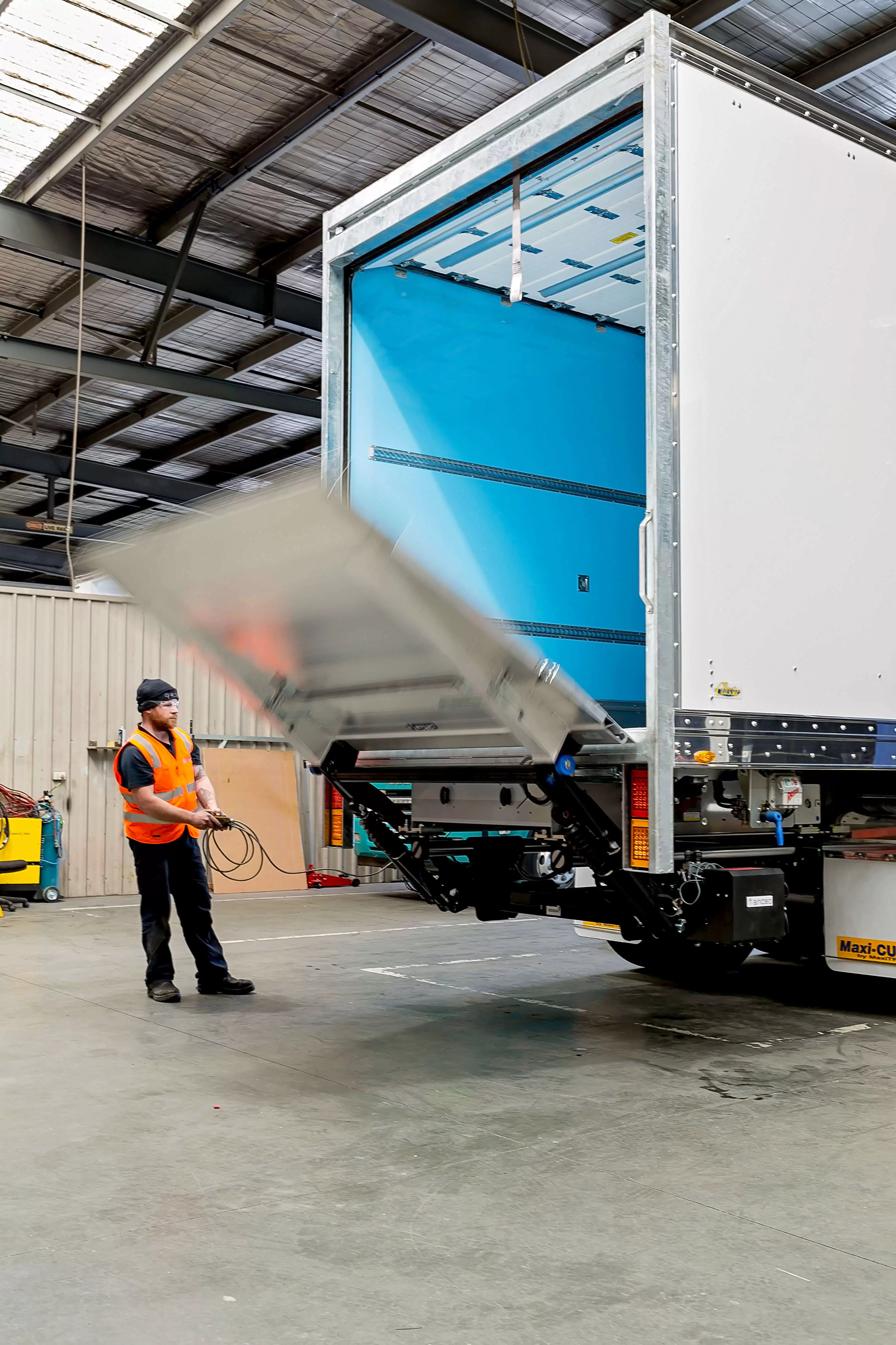 worker operating truck's loading ramp