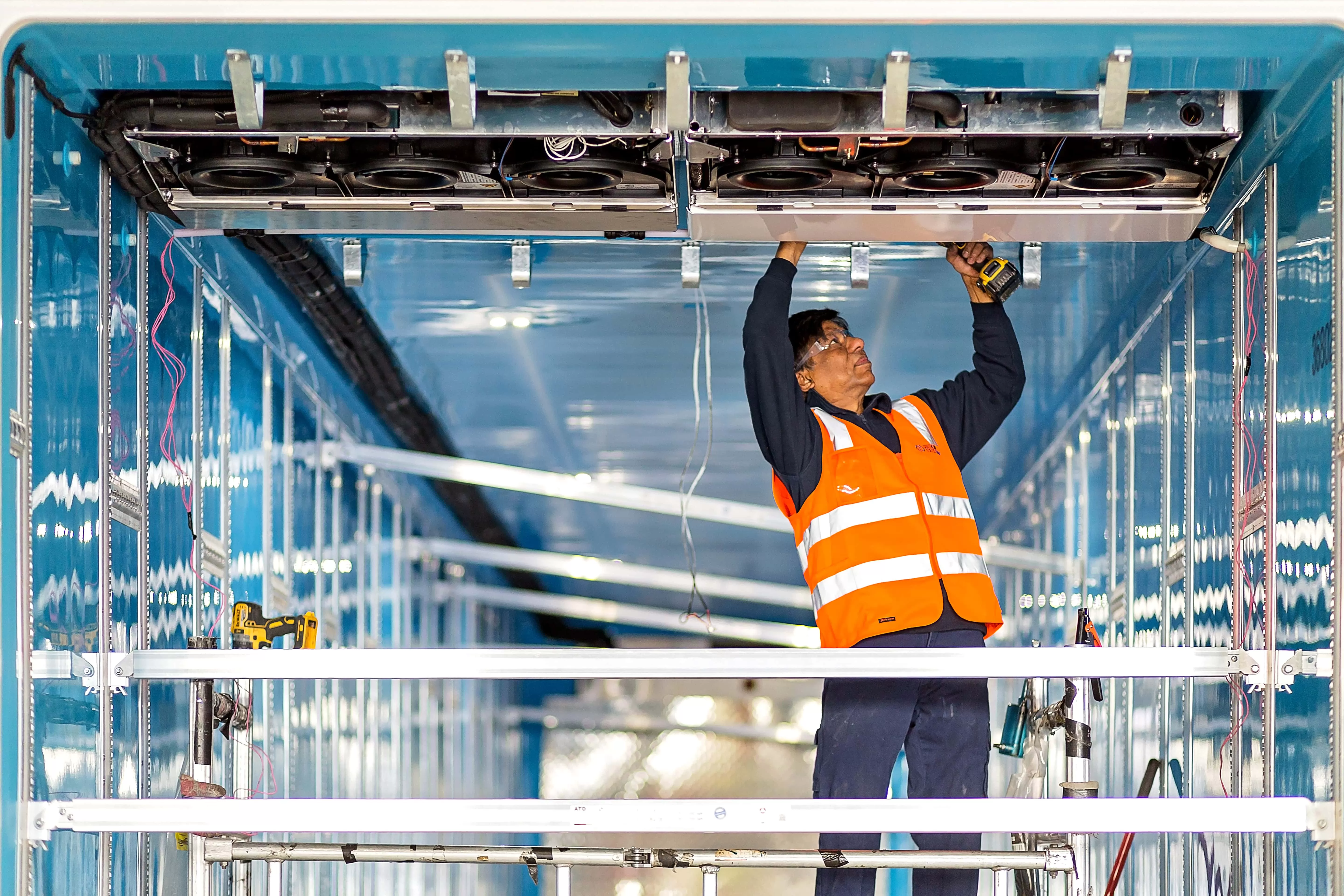 worker installing refrigeration trailer ceiling